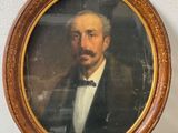 portrait of a man in a suit and bow tie in a wooden frame