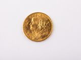 gros plan d'une pièce d'or sur une surface blanche