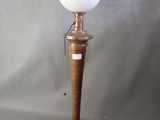 a wooden lamp with a white glass shade on top of it