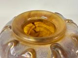 a brown vase with a yellow top sitting on a table