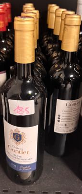 several bottles of wine are lined up on a shelf in a store