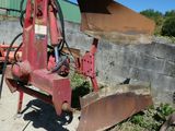 une machine rouge qui est à l'arrêt dans la poussière