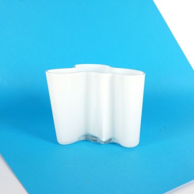 une tasse blanche posée sur une surface bleue