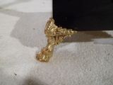 une figurine en or posée sur une table noire
