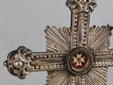 silver cross with a red star in the center