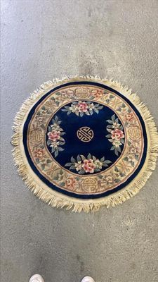 une personne debout à côté d'un tapis posé à même le sol