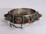 silver bracelet with red coral beads and a chain