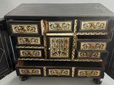 a black and gold chest of drawers with a door open