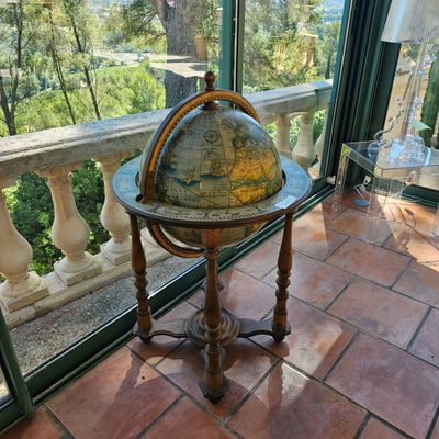 un vieux globe terrestre posé sur une table devant un balcon