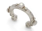 a close up of a silver cuff with pearls on it