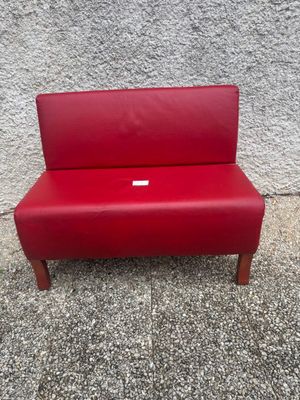 un banc rouge posé sur le trottoir