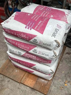 plusieurs sacs de ciment empilés les uns sur les autres sur une palette