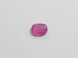 a pink sapphire stone on a white surface