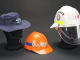 three hats and a hard hat on display on a table