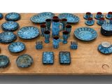 une table sur laquelle sont disposées de nombreuses assiettes et bols bleus