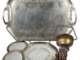 un plateau en argent sur lequel sont disposées des assiettes et des tasses en argent