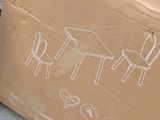 a cardboard box with a drawing of a table and chairs on it