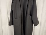 the coat is hanging on a hanger in front of a white curtain
