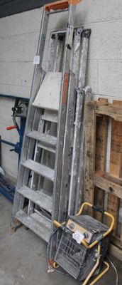 a ladder that is leaning against a wall next to a pile of pallets