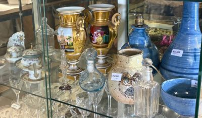 une vitrine en verre dans laquelle sont exposés de nombreux vases différents