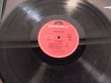 a black record on a table with a red label on it