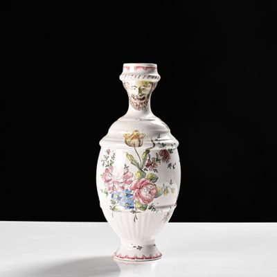 un vase blanc avec des fleurs sur une table