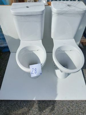 two toilets sitting on a table with a price tag on it