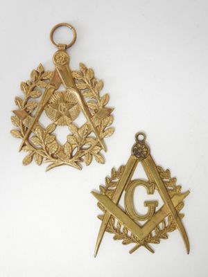 Deux symboles maçonniques dorés sont représentés sur un fond blanc