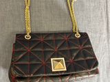 un sac à main noir et rouge avec une chaîne dorée