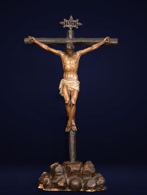 a statue of jesus on the cross on top of a pile of rocks