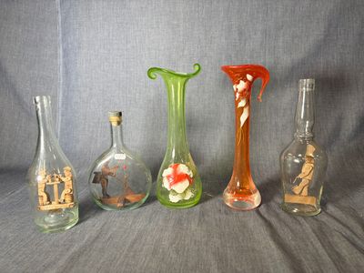 quatre vases en verre sont alignés sur un fond gris