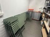 a room filled with lots of green chairs and shelves