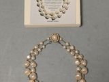pearl necklace and bracelet with a picture of a woman ' s face in a frame