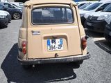 a small car parked in a parking lot with other cars in the background