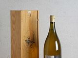 une bouteille de vin à côté d'une caisse en bois sur une table