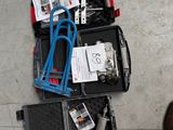une valise remplie d'outils posée par terre à côté d'une paire de chaussures