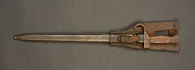an old metal pipe cutter on a gray surface with a brown handle