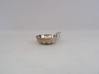 une vieille coupe en argent sur laquelle repose une cuillère