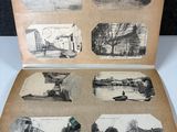 an old photo of an open book with pictures of buildings and trees