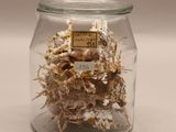 a glass jar with a bunch of dried flowers inside of it