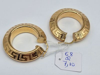 deux boucles d'oreilles en anneau dorées avec une étiquette de prix sur fond blanc