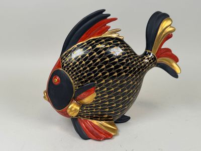 figurine de poisson noir et or avec accents rouges et or