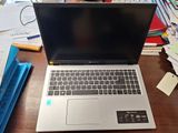 a laptop that is sitting on a desk in front of a pile of papers