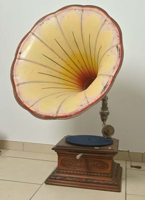 un vieux gramophone posé sur un support dans une pièce