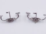 pair of silver plated earrings on a white surface with a white background