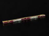 a close up of a red and white diamond bar brooch