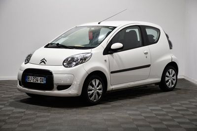 la petite voiture blanche est garée dans la pièce au sol en damier