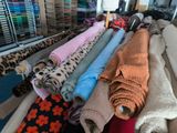 many different types of fabric on a rack in a store