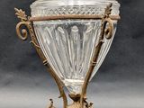 an antique glass covered urn on a stand on a gray background