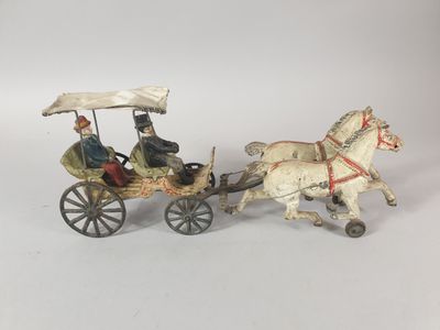 two figurines of people riding in a horse drawn carriage